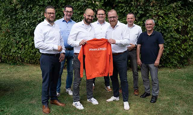 Gruppenbild der Geschäftsführer der Stadtwerkenergie, zwei Personen halten einen orangen Pullover mit Aufschrift #teamJÜRGEN
