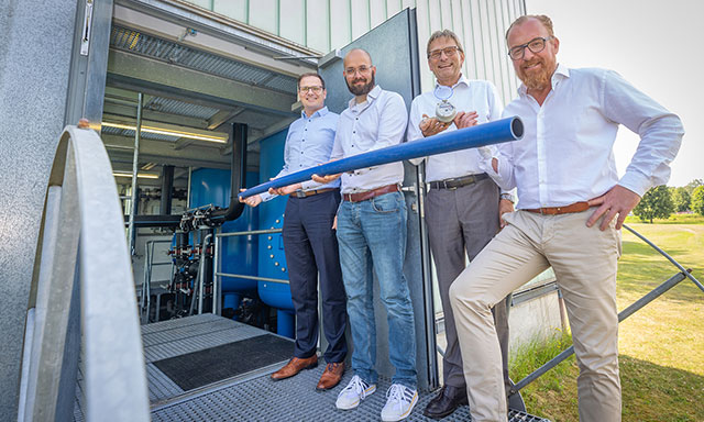 Die Geschäftsführer der Stadtwerke Bad Salzuflen, Detmold, Lemgo und Oerlinghausen halten gemeinsam ein Wasser-Rohr