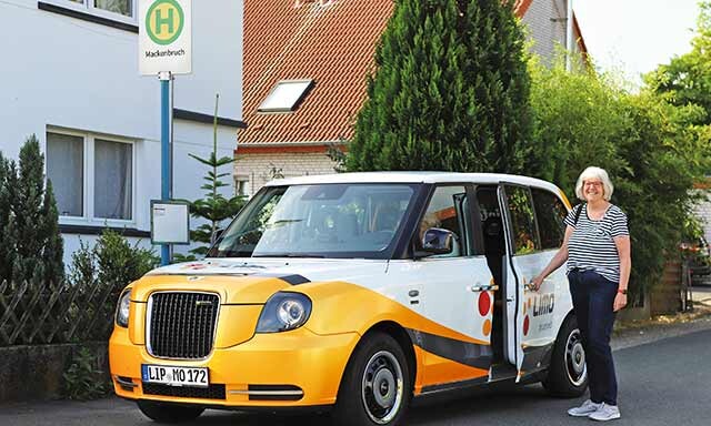 Frau steht neben der LIMO