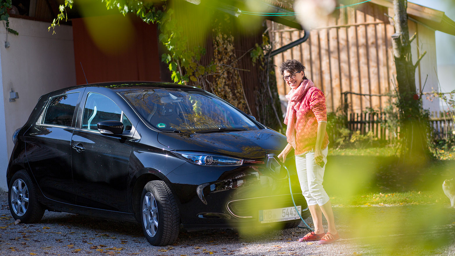 Frau lädt ihr Elektrofahrzeug an einer Wallbox