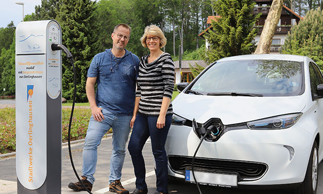 Paar steht mit seinem Elektroauto an einer Ladesäule der Stadtwerke Oerlinghausen